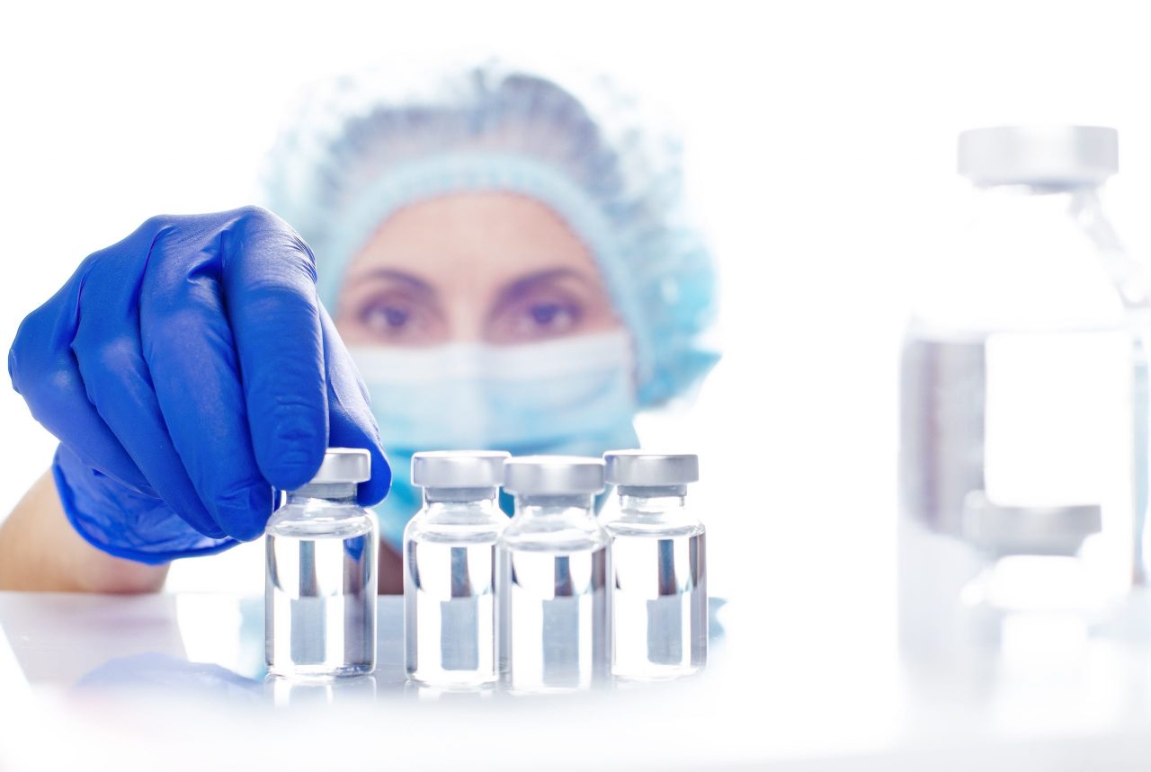 female-nurse-in-safety-mask-and-gloves-takes-vial-A4WCZYQ-scaled-1280x859.jpg